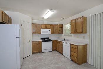 A kitchen with white appliances and wooden cabinets